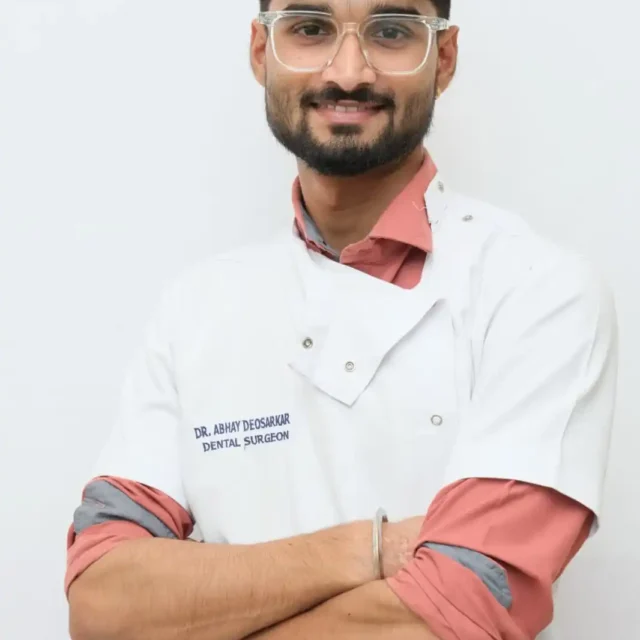 Dr. Abhay, a dentist, wearing a white coat and smiling in a nextgen dental and cosmetic clinic.